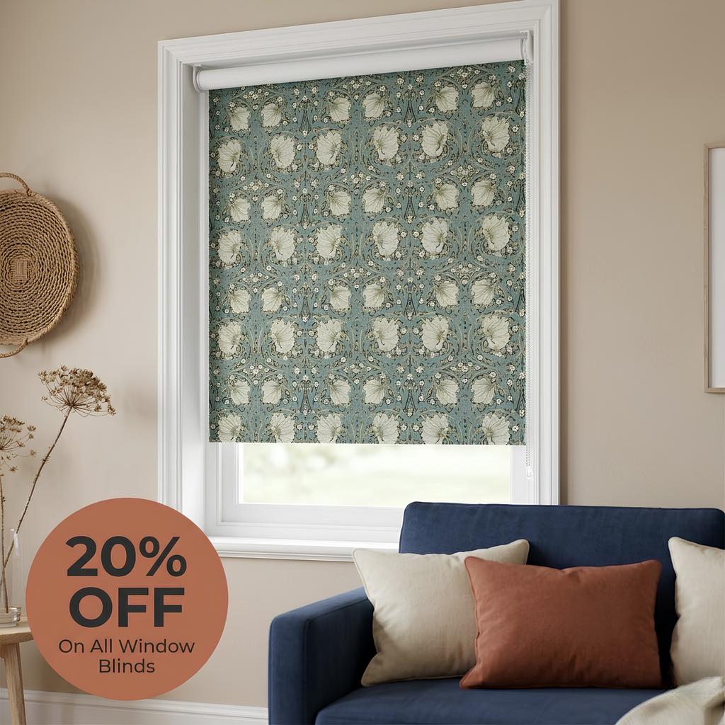 Patterned roller blind in a window with a blue sofa and decorative pillows, featuring a 20% off discount on window blinds.