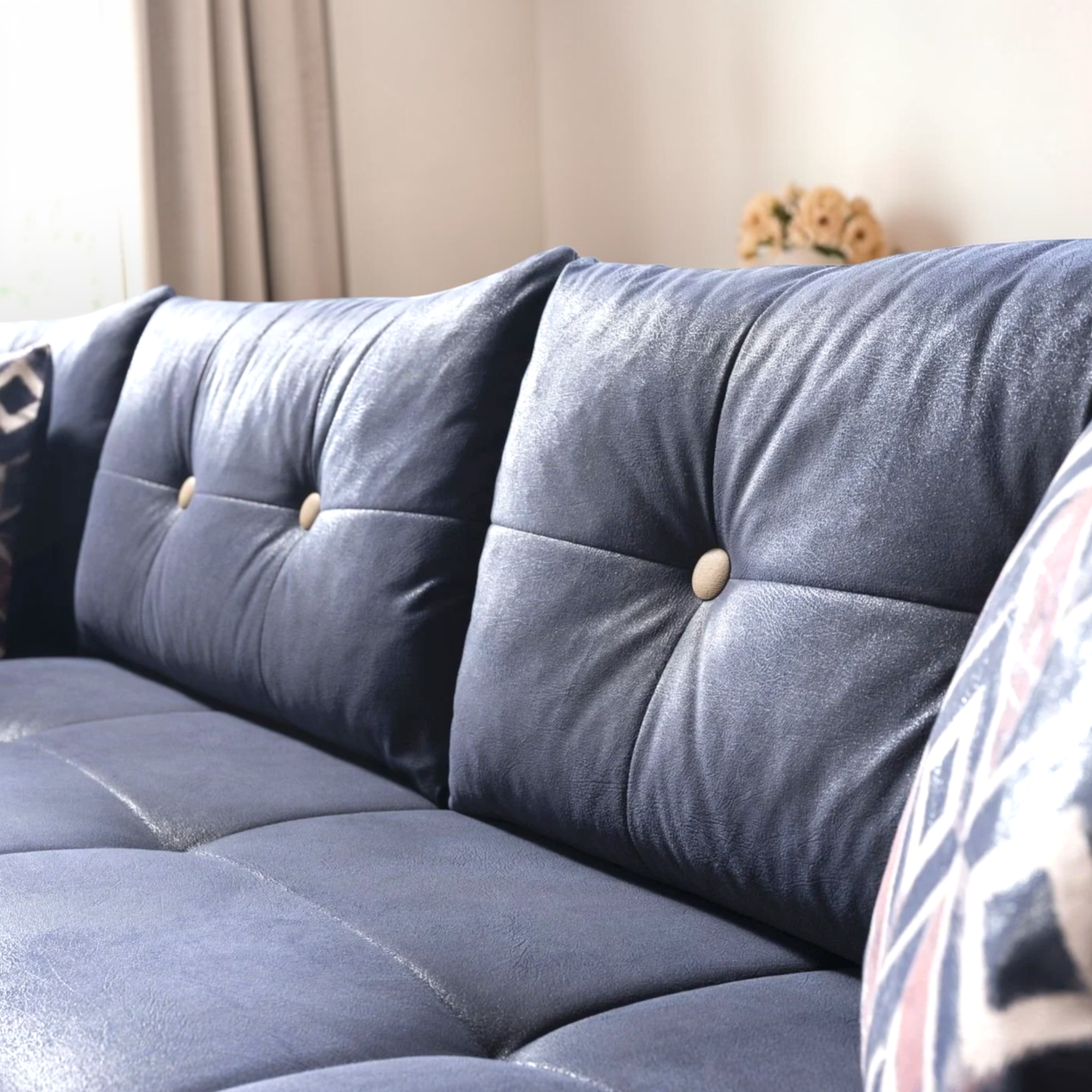 Blue tufted sofa with decorative pillows in a living room setting.