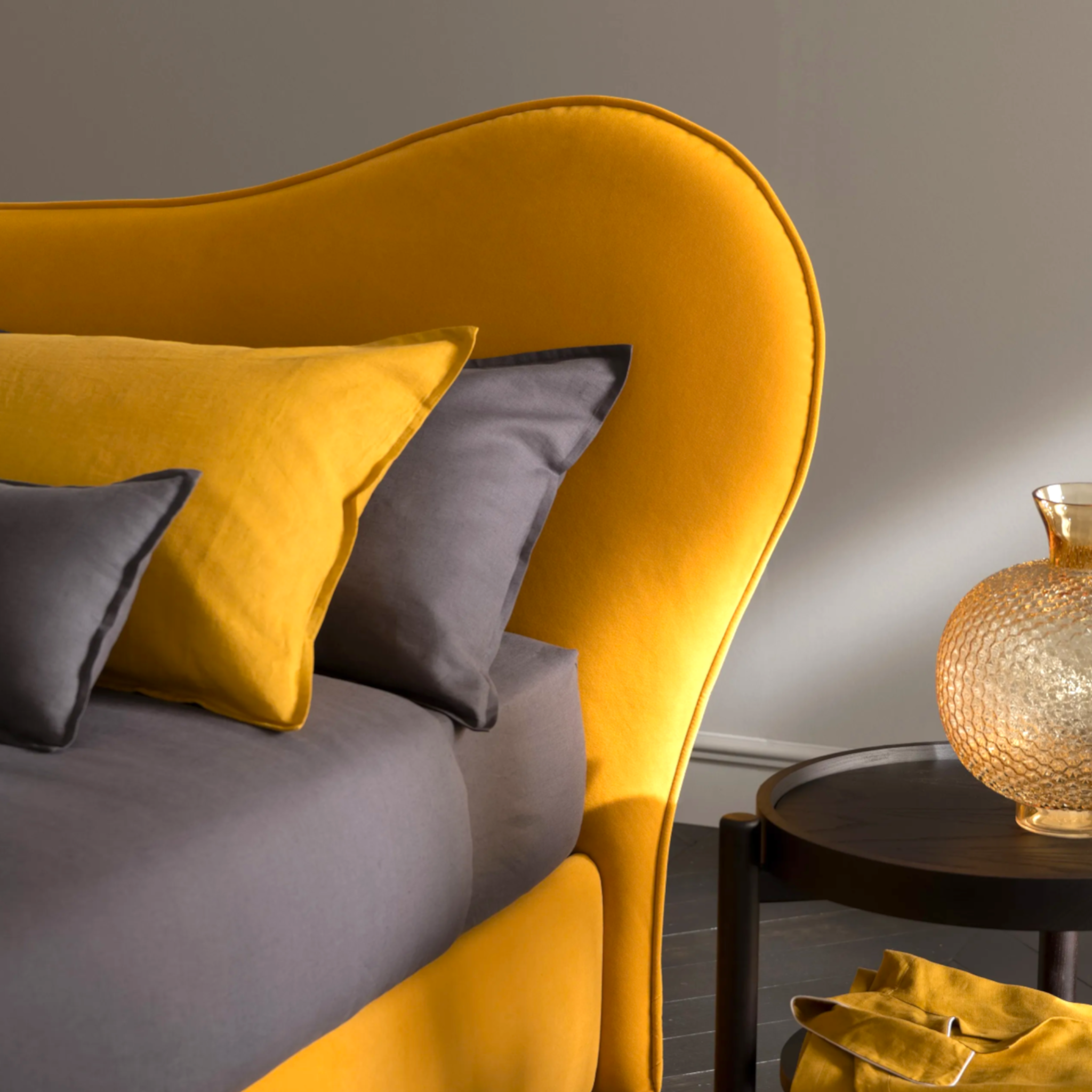 Yellow and gray sofa with decorative pillows in a room setting.