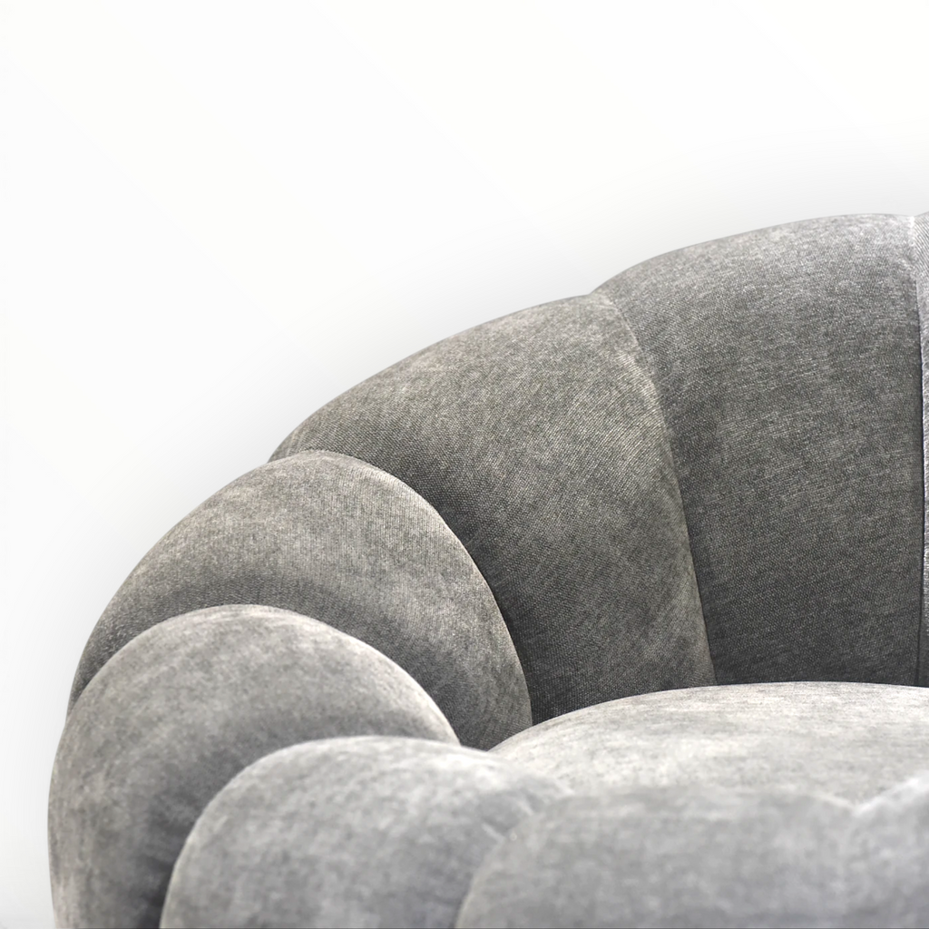 Close-up of a textured gray sofa with a white background
