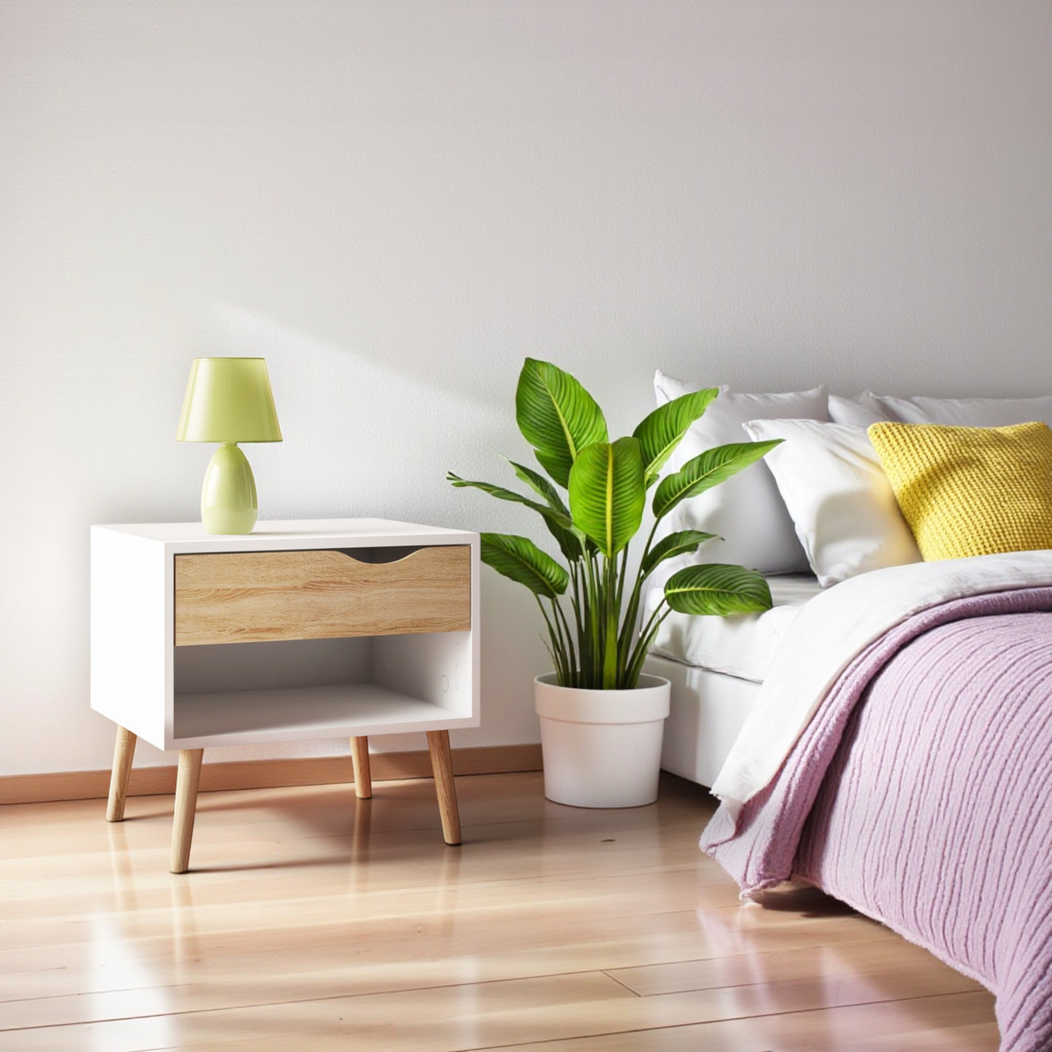 Modern bedroom with a nightstand, lamp, plant, and bed with pink bedding.