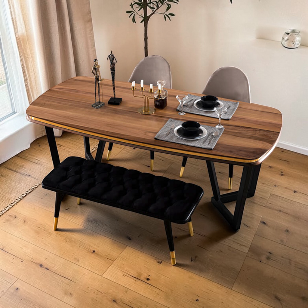 Dining room with wooden table, chairs, and a black bench on a wooden floor.
