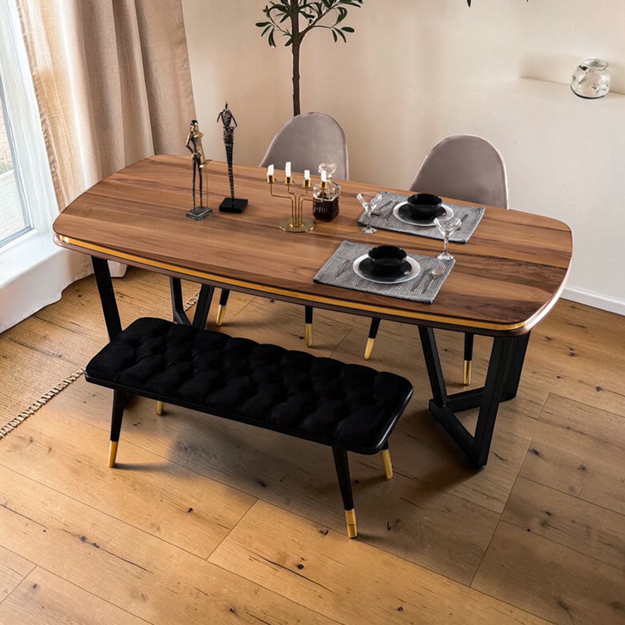 Dining room with wooden table, chairs, and a black bench on a wooden floor.