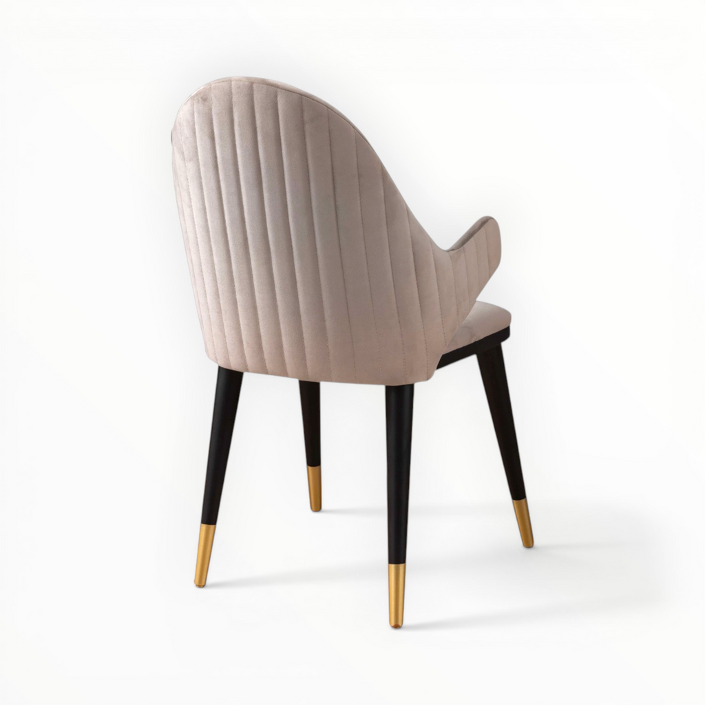 Beige chair with black legs and gold tips on a white background