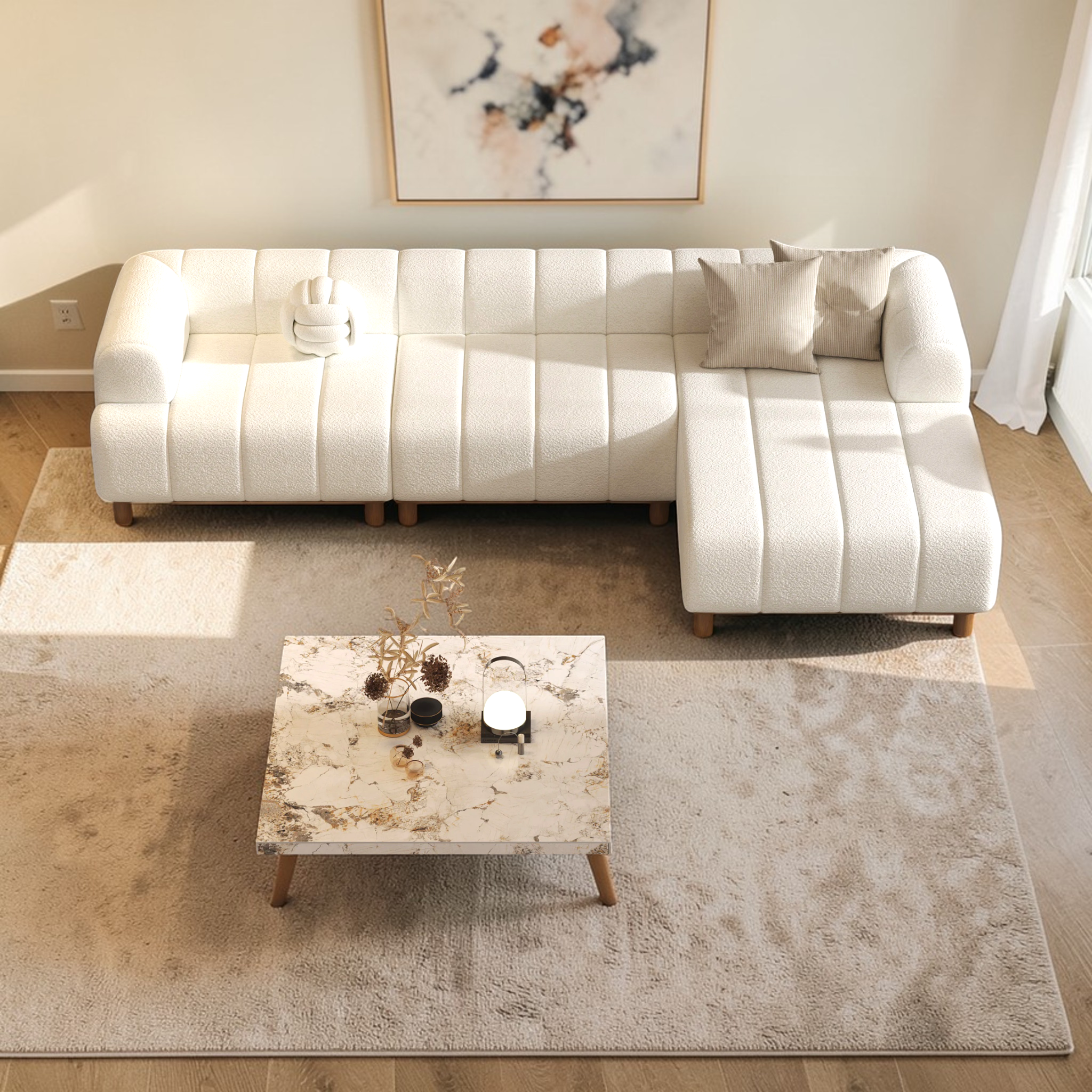Modern living room with a white sectional sofa, marble coffee table, and abstract art on the wall.