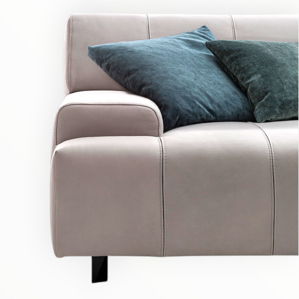 Beige sofa with blue and green cushions on a white background