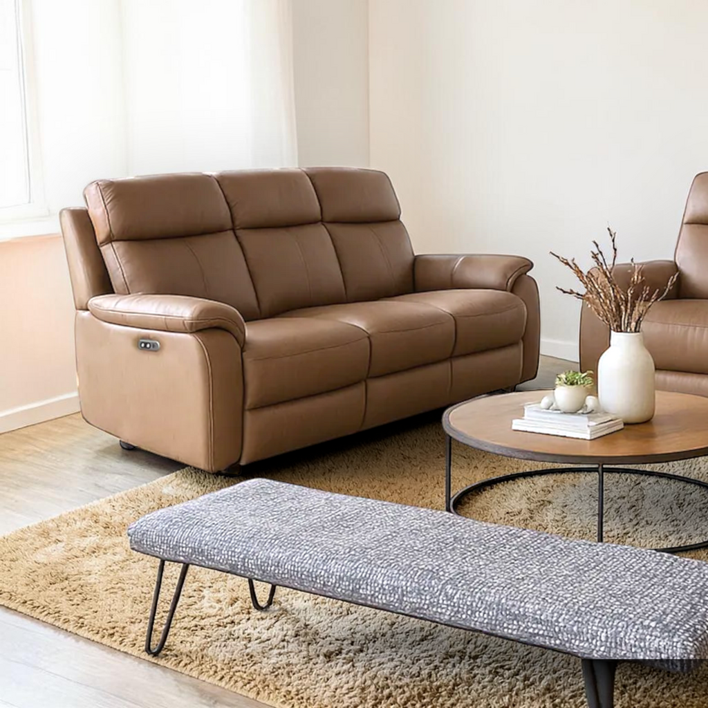 Brown leather sofa in a living room with a coffee table and bench.