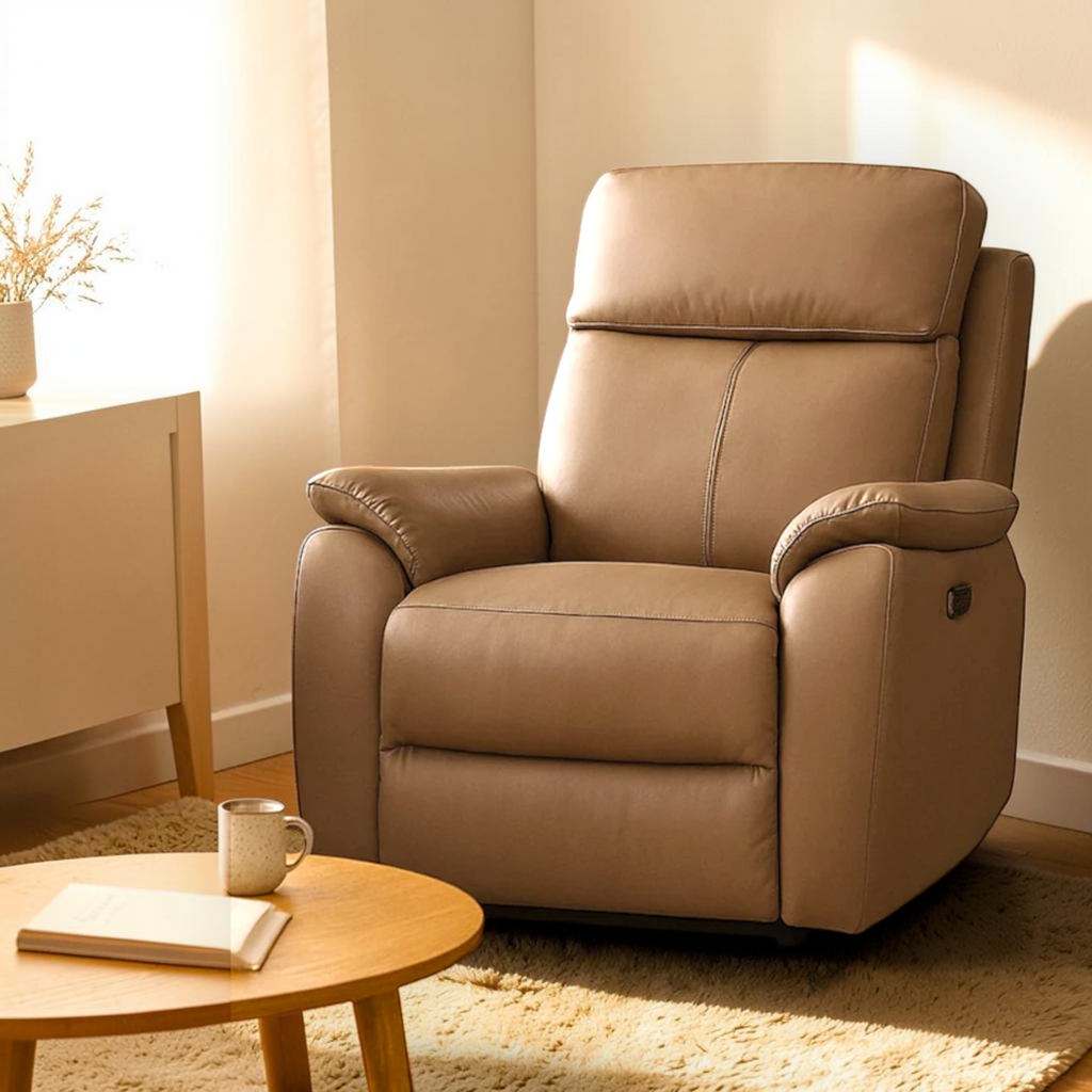 Beige recliner chair in a living room setting with a coffee table and book.