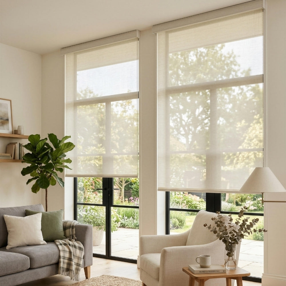 Living room with large windows, gray sofa, white armchair, and a plant.