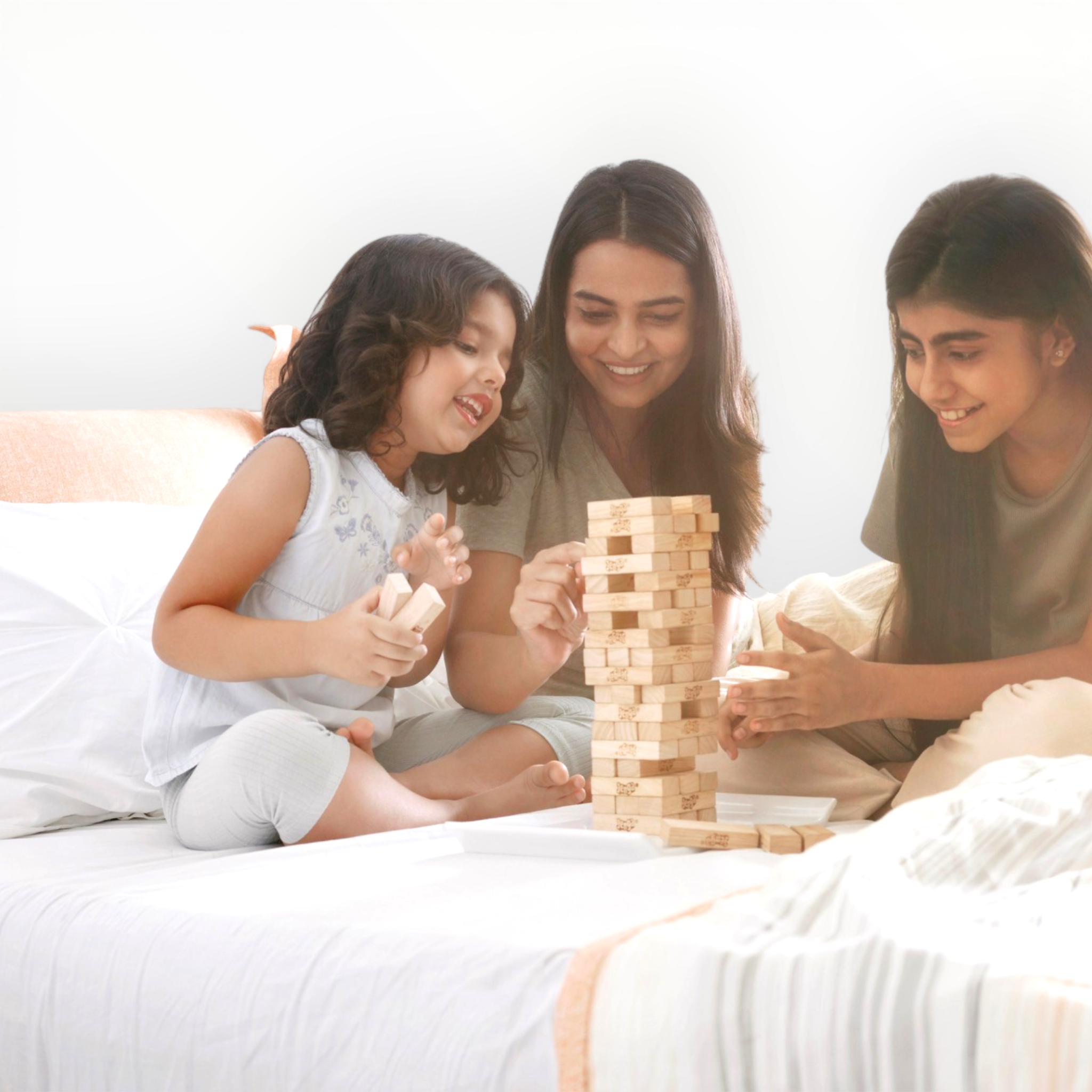 Woman and two children playing with a wooden block tower game on a bed.
Sleepwell Cheer Mattress – Authorised Dealer Hyderabad