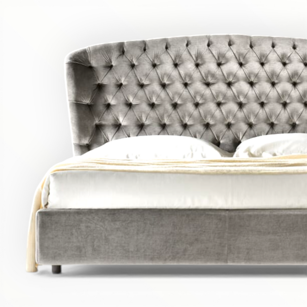 Gray tufted bed with white bedding on a white background