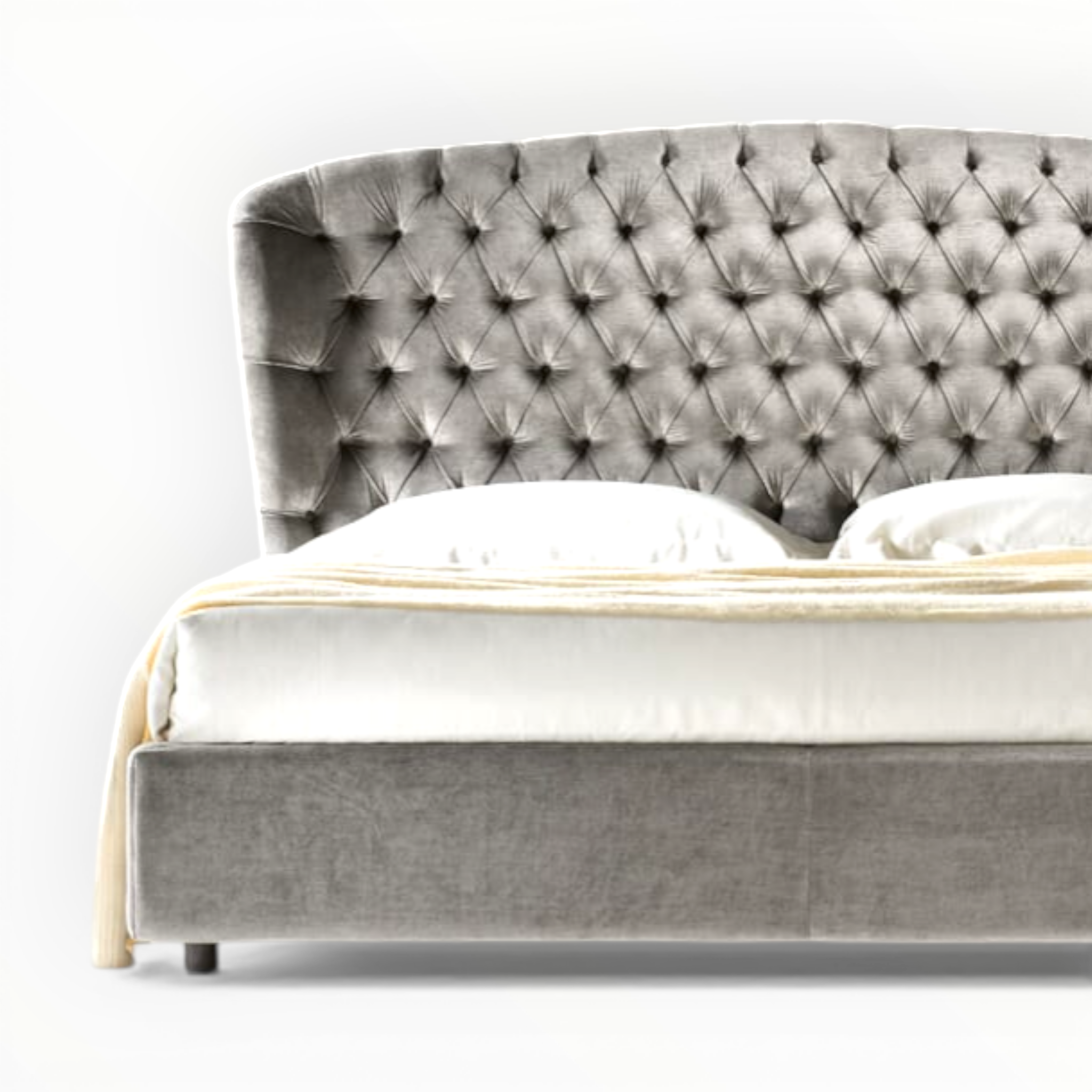 Gray tufted bed with white bedding on a white background