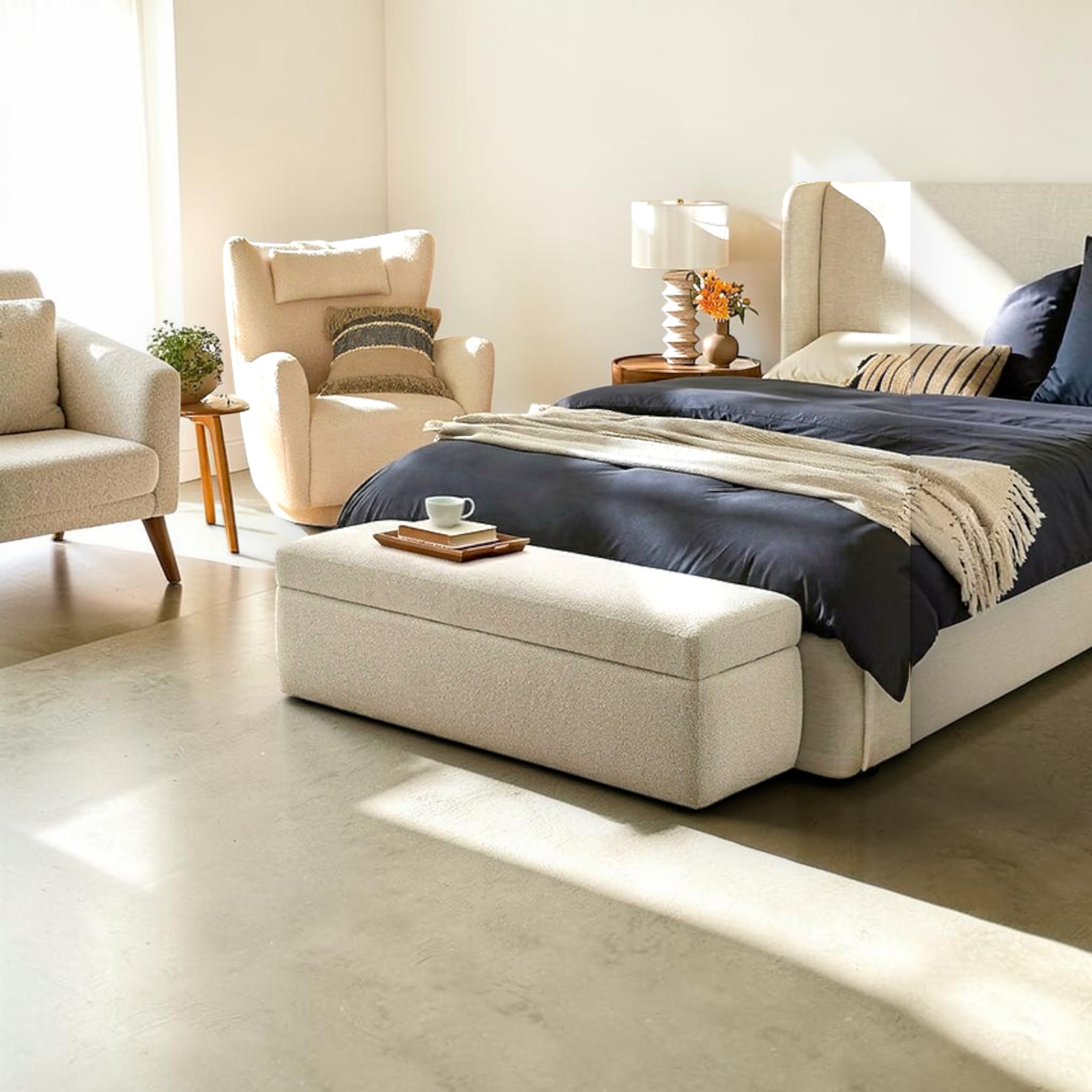 Modern bedroom with a bed, armchair, ottoman, and side table.
