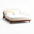 Modern bed with wooden frame and white bedding on a white background