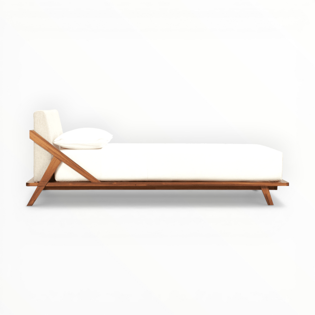 Modern bed with wooden frame and white mattress on a white background