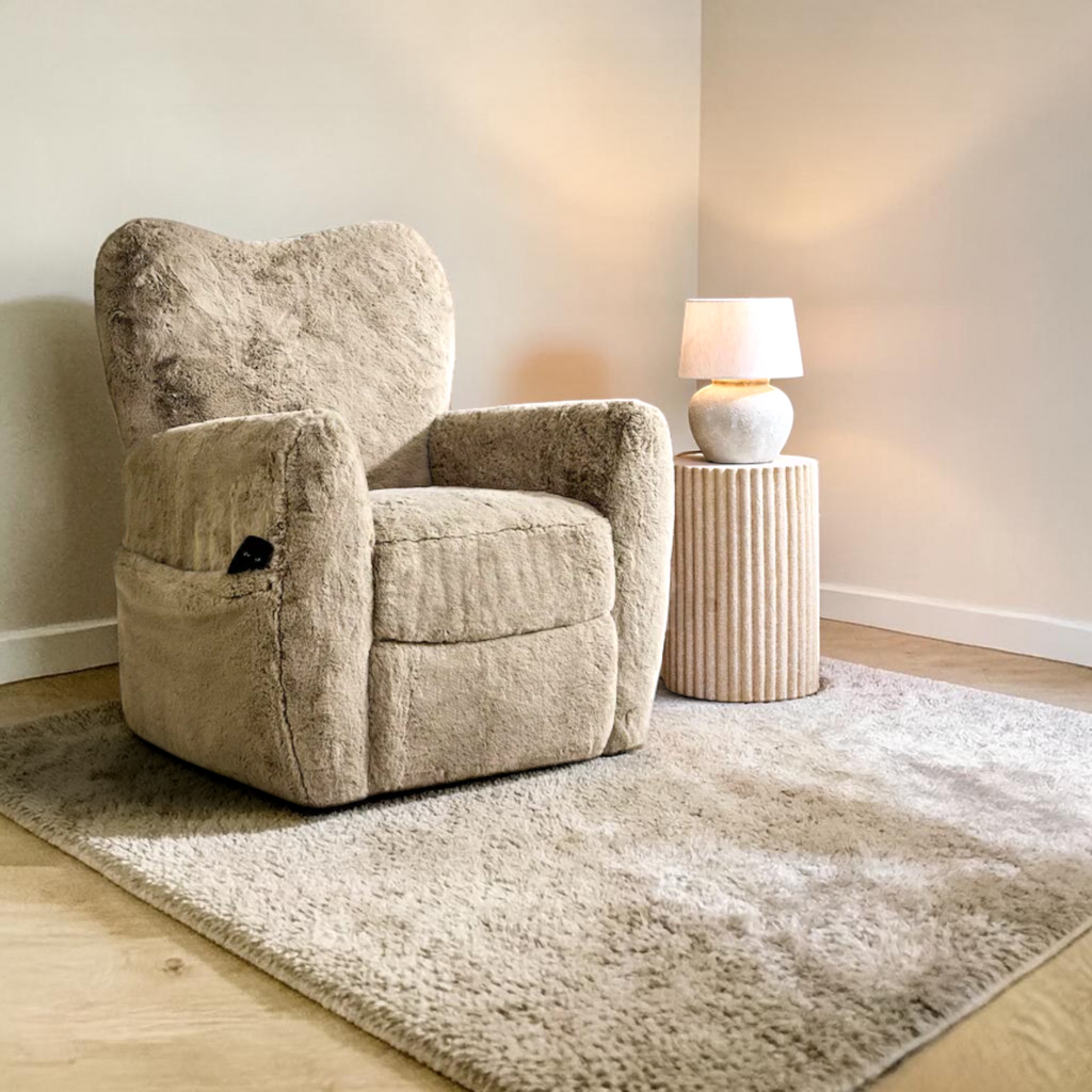 Beige armchair in a room with a side table and lamp