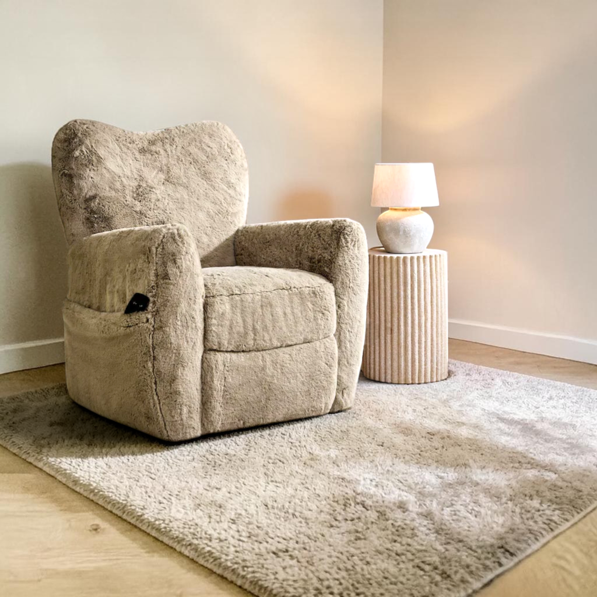 Beige armchair in a room with a side table and lamp