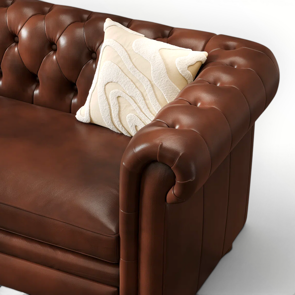 Brown leather sofa with a decorative pillow on a white background