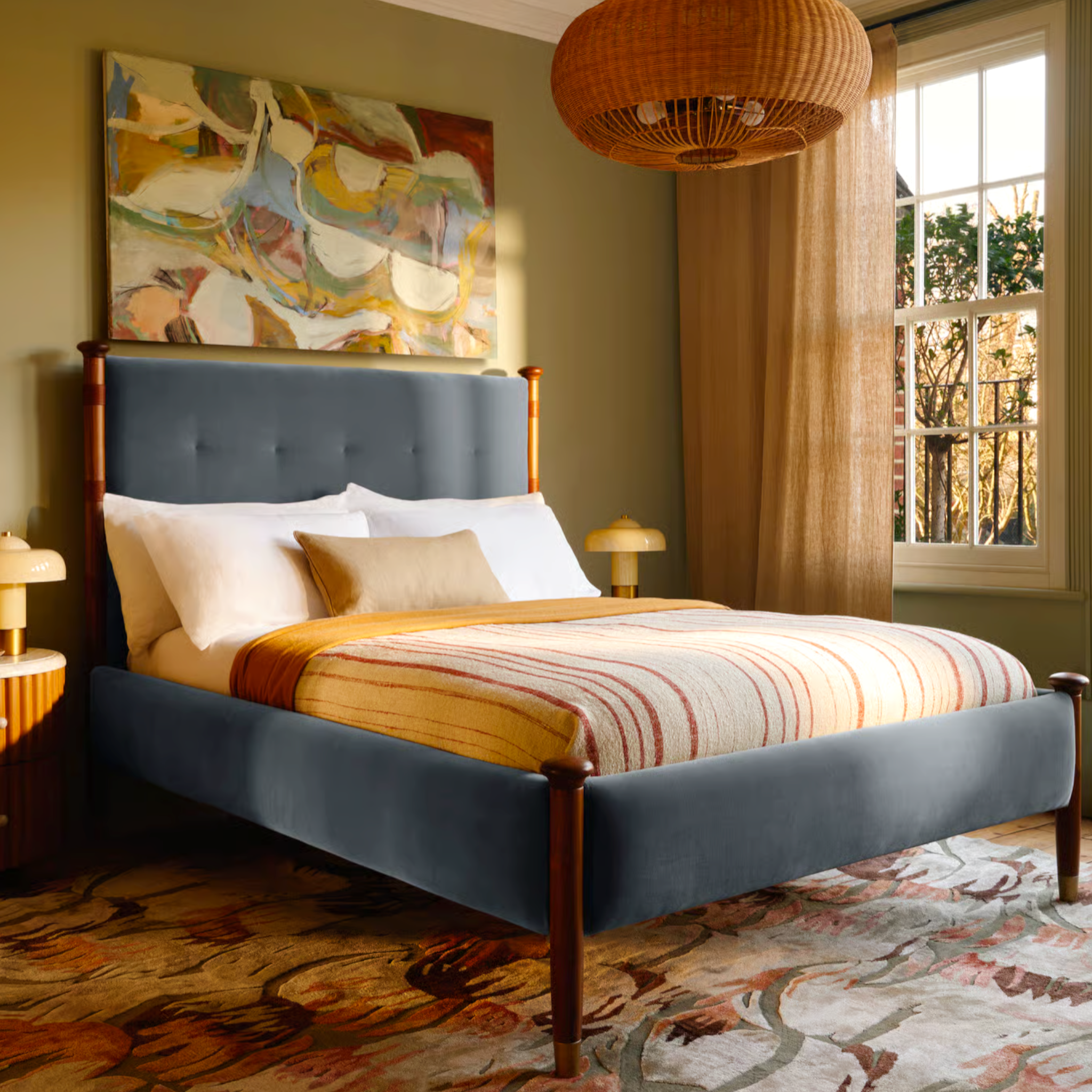 Bedroom with a blue upholstered bed, abstract painting, and window with curtains.