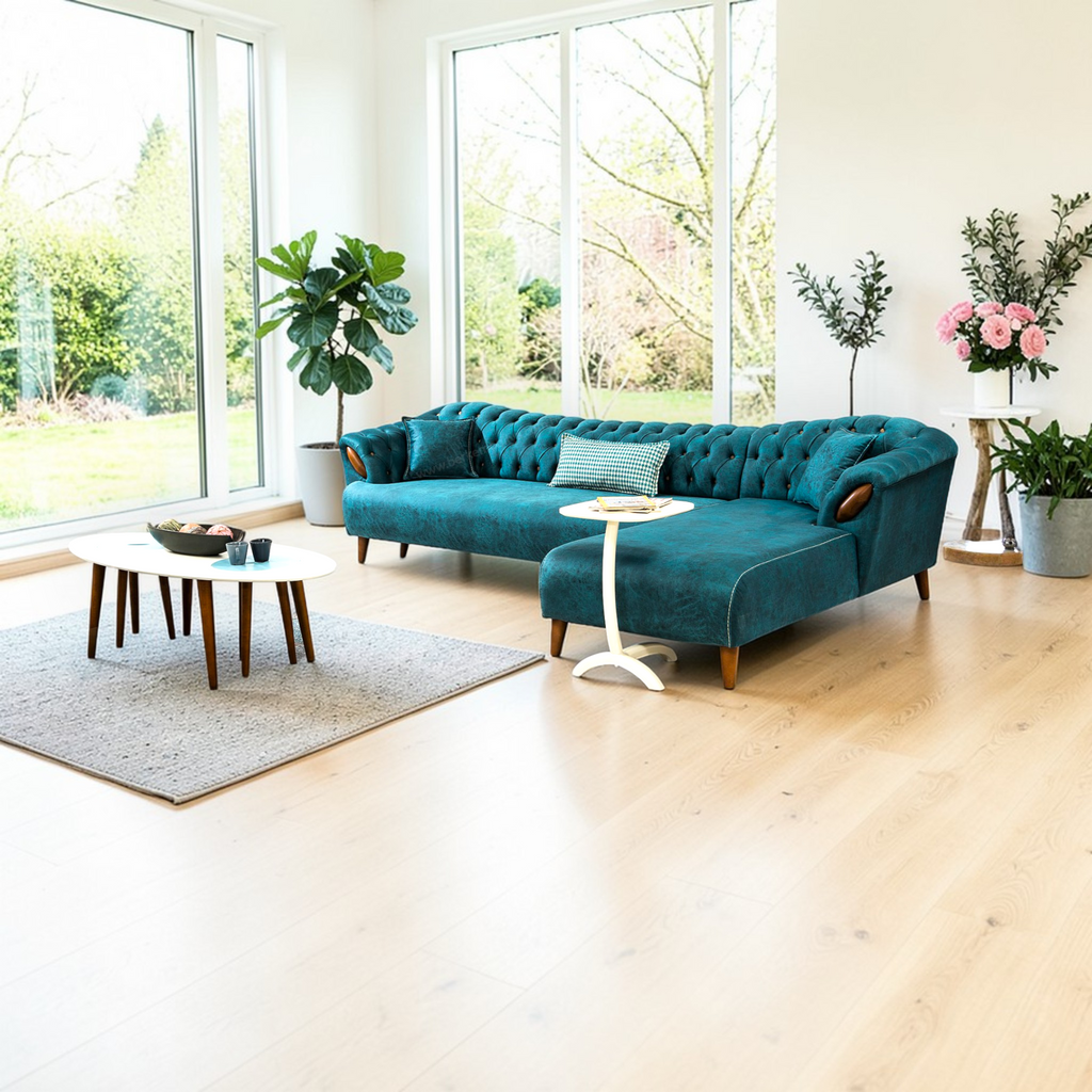Modern living room with a teal sofa, coffee table, and decorative plants.