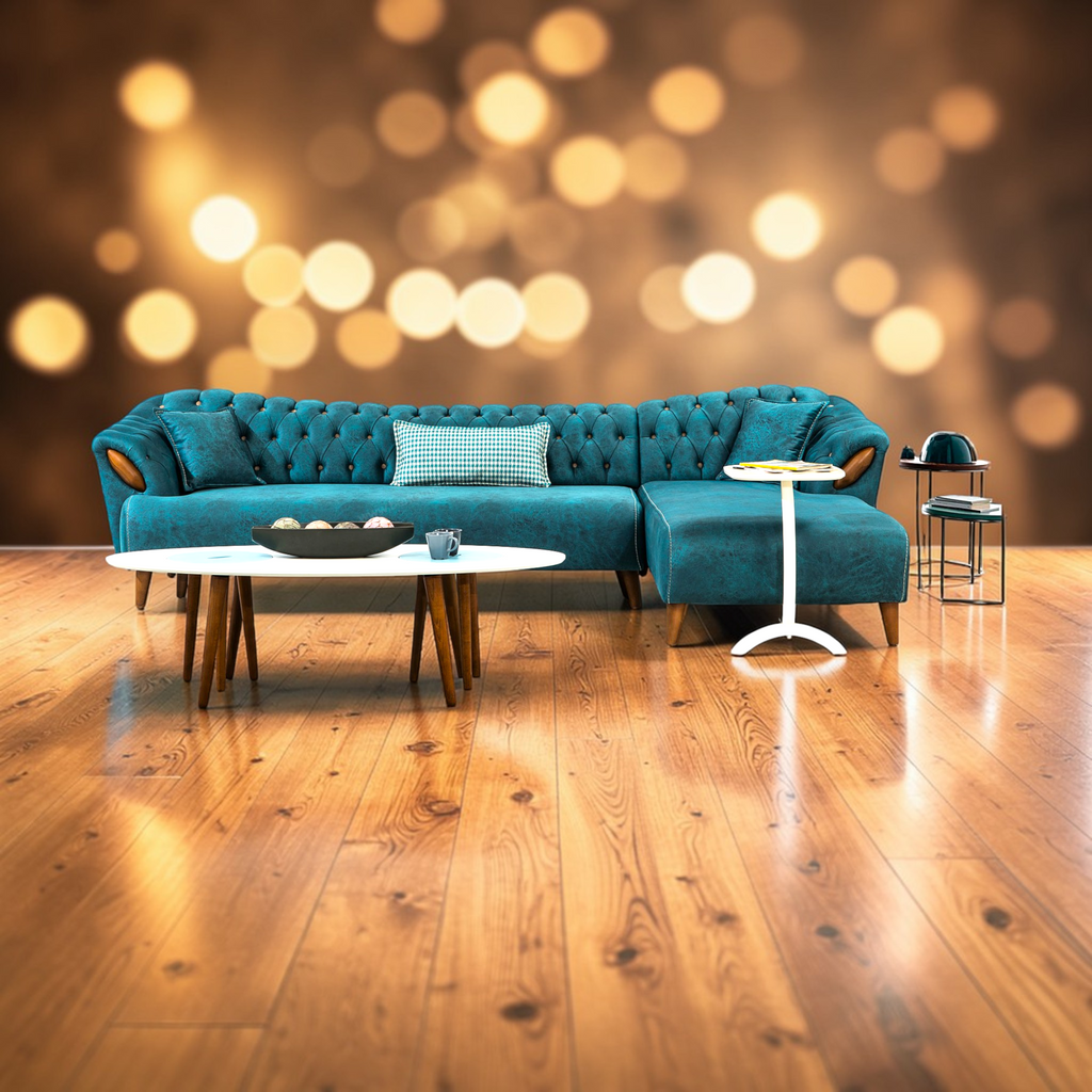 Teal sectional sofa in a living room with wooden floor and blurred lights in the background