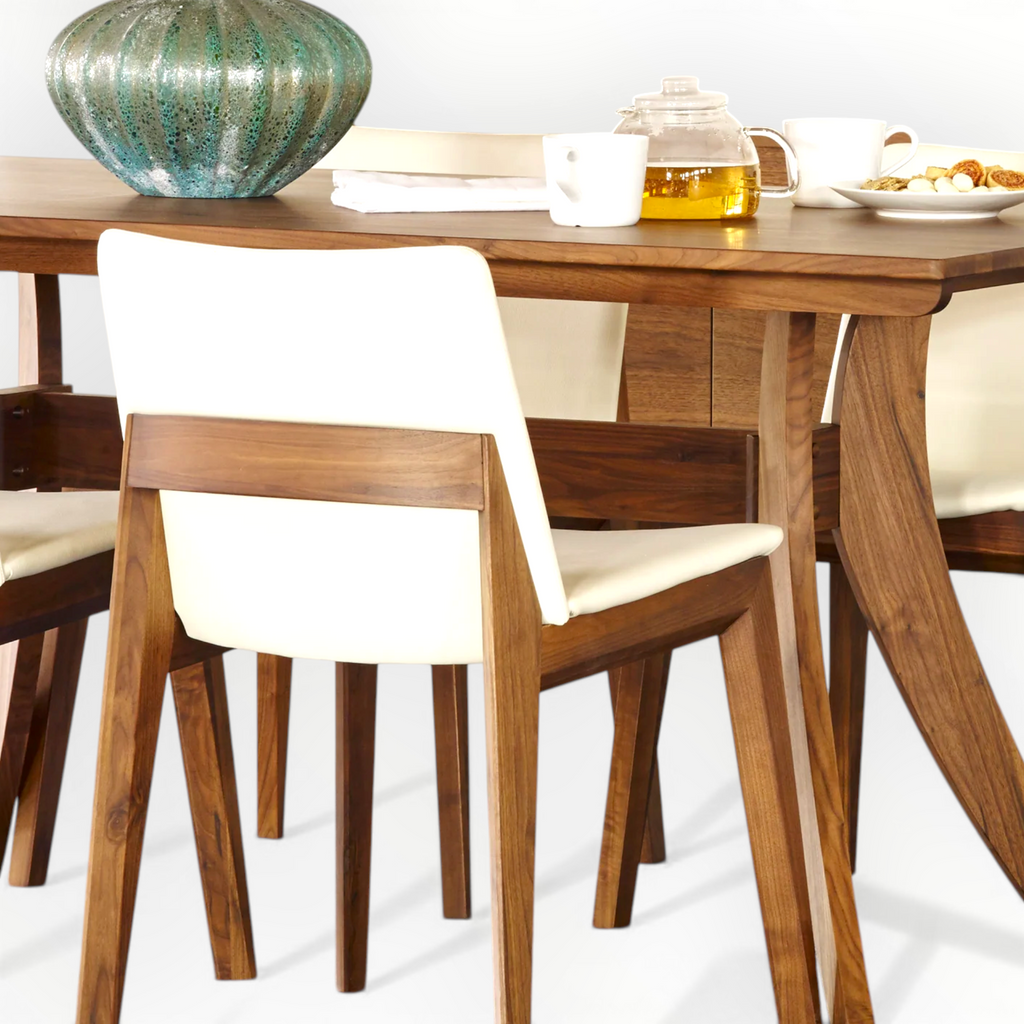 Wooden dining table with white chairs on a light background