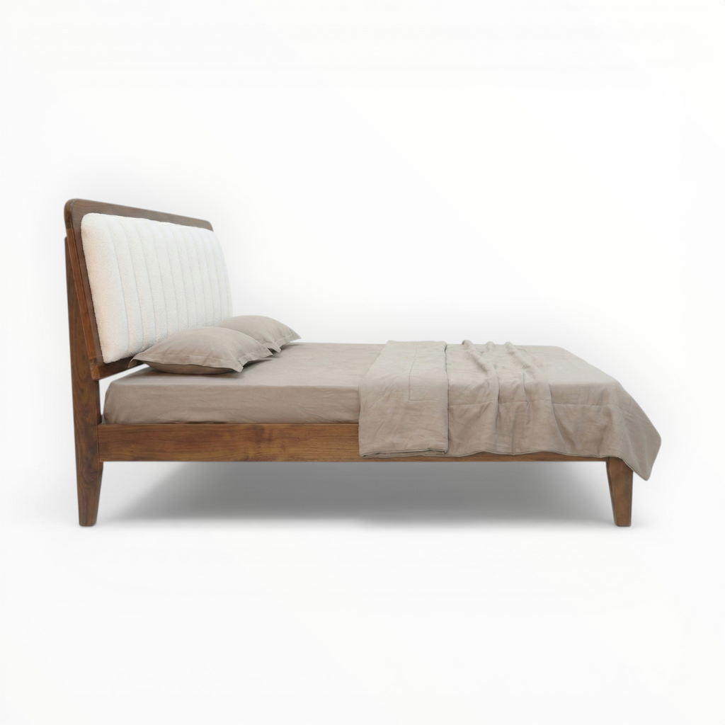 Wooden bed with beige bedding on a white background