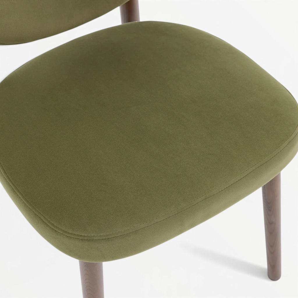 Emerald dining chair seat close-up – olive green velvet upholstery with piped edge detail