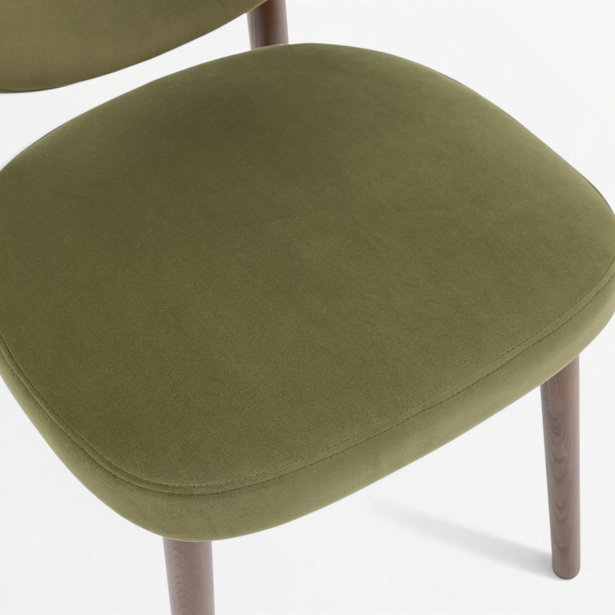 Emerald dining chair seat close-up – olive green velvet upholstery with piped edge detail